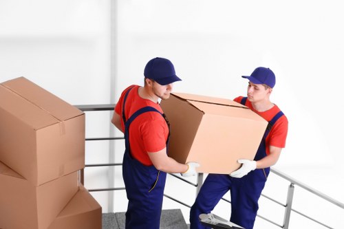 Professional movers packing household items for a move in Lee