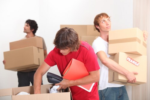 Removal team navigating stairs during a flat move in Lee