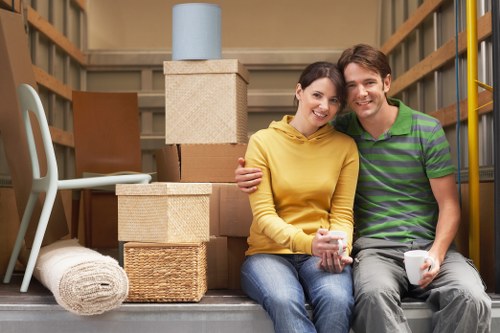 Removal specialists carrying furniture through a residential property in Lee