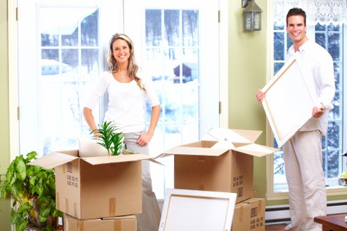 Packed moving boxes and furniture ready for transport in Lee